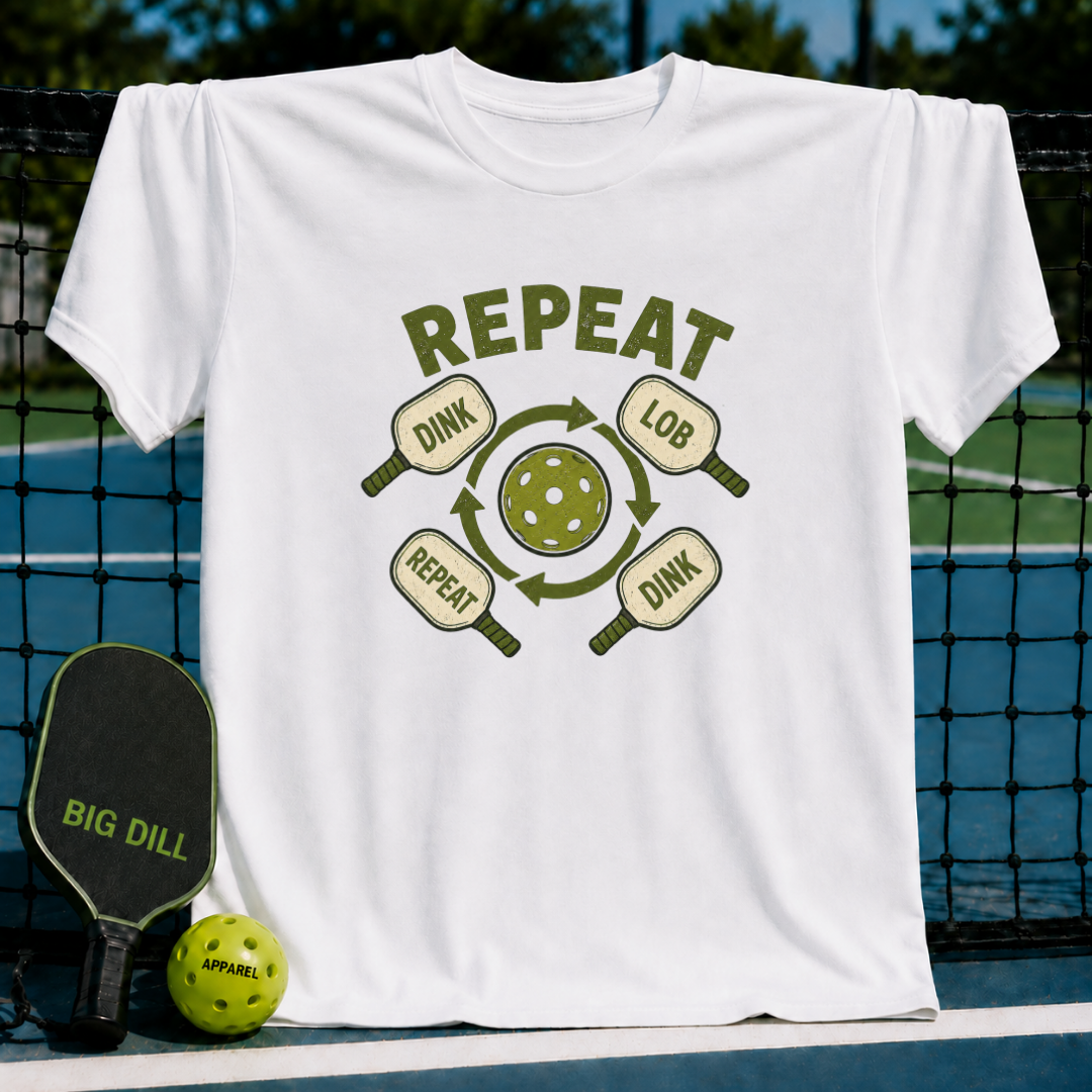 White crew neck t-shirt featuring a green pickleball graphic with paddles and the text Dink Lob Dink Repeat.