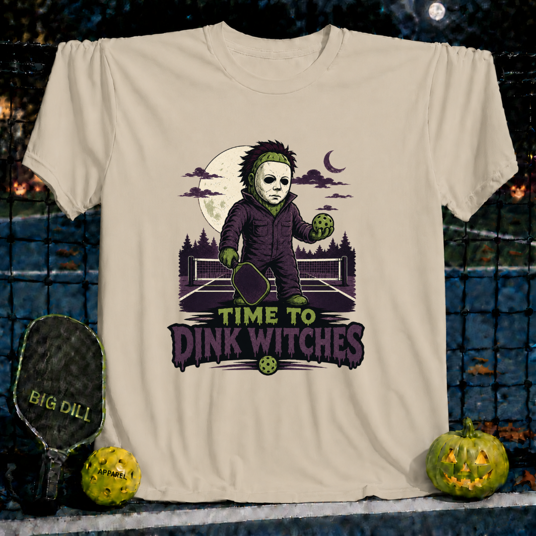 Sand-colored unisex t-shirt featuring a spooky pickleball-playing character and the text Time to Dink Witches.
