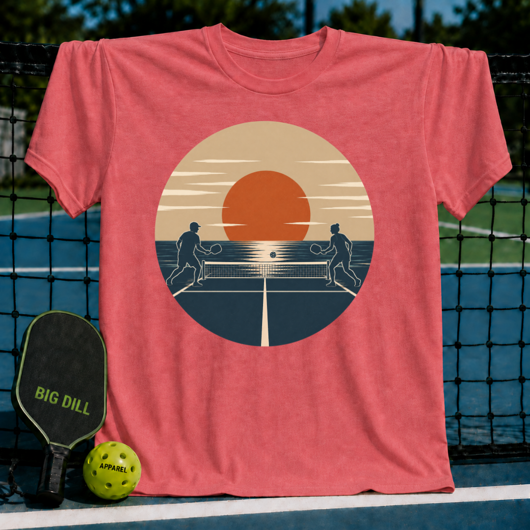 Red unisex t-shirt featuring a retro sunset pickleball court graphic with two silhouettes playing on a court.