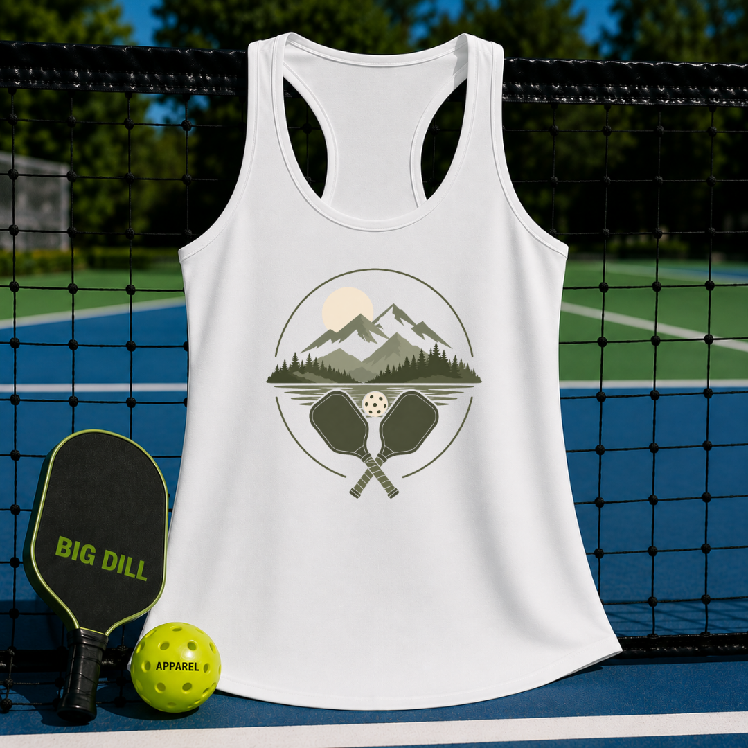 White racerback tank top with a retro mountain and pickleball paddle graphic, displayed on a pickleball court net.