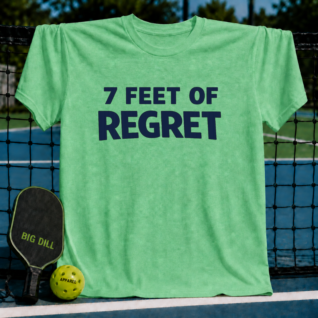 Light green unisex t-shirt featuring the navy blue text 7 FEET OF REGRET, displayed on a pickleball court with a paddle and ball.