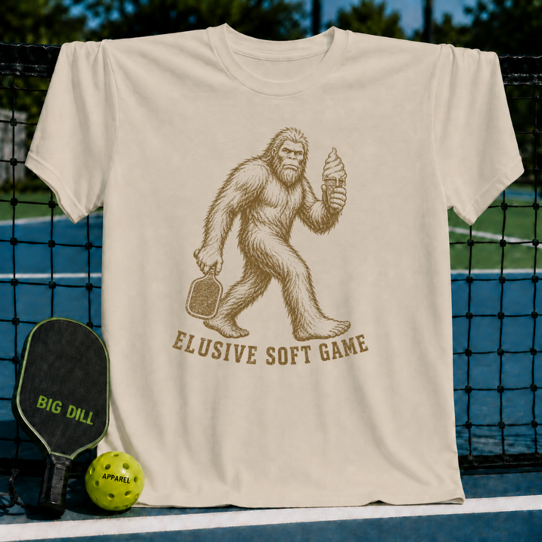 Sand-colored unisex t-shirt featuring a vintage Sasquatch graphic holding a pickleball paddle and a melting ice cream cone.