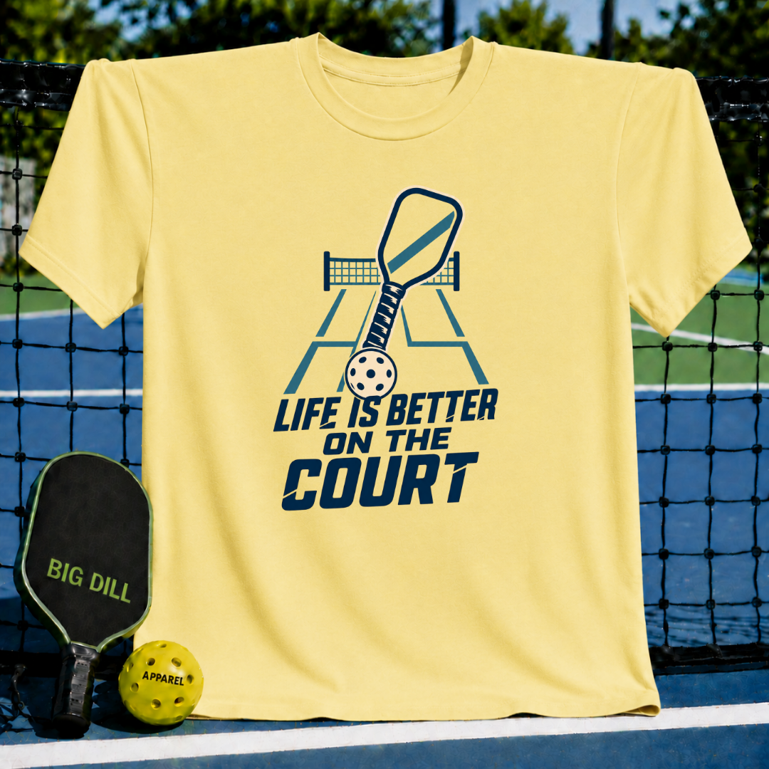 Light yellow crew neck t-shirt featuring a blue pickleball court graphic with the text Life is Better on the Court.