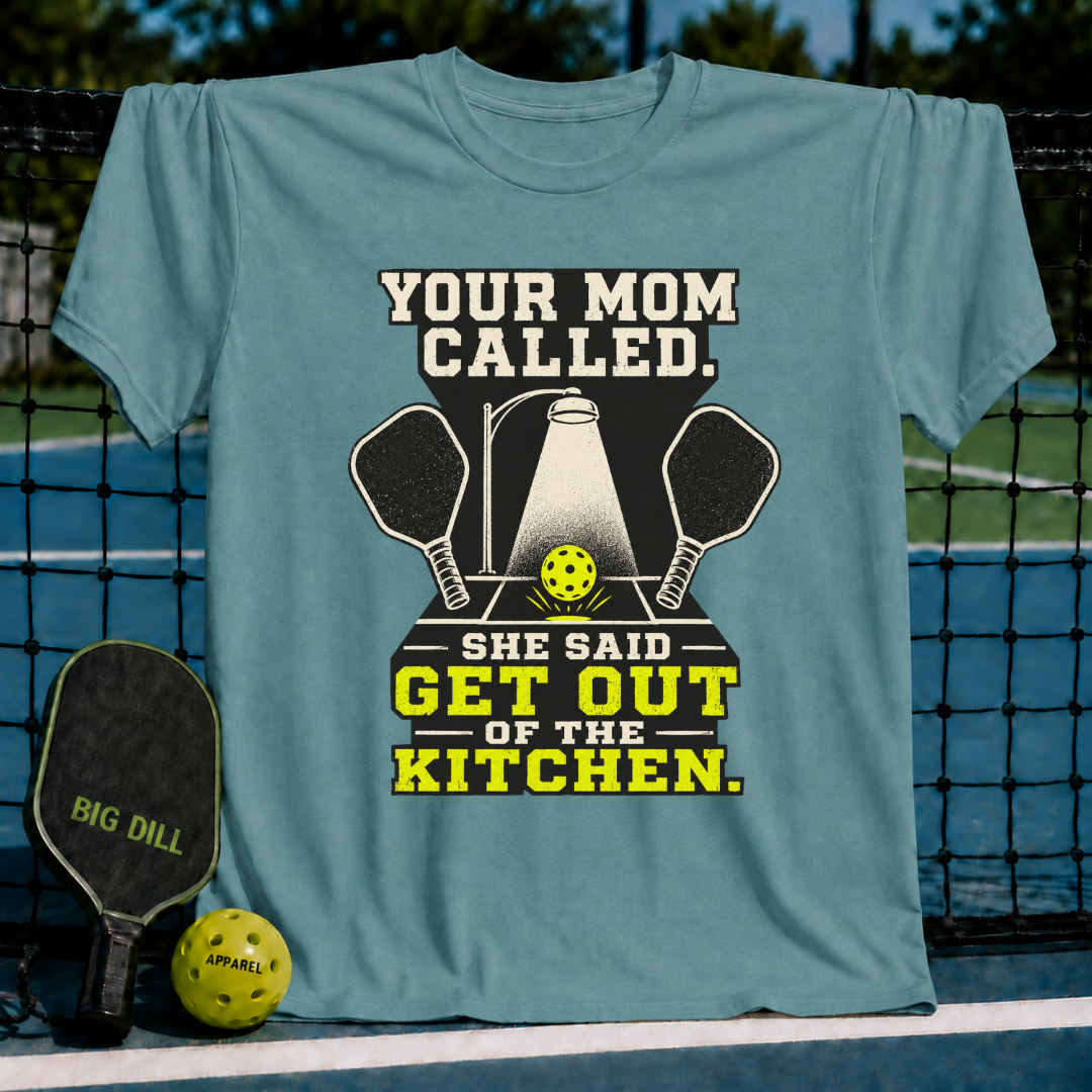 Blue-grey unisex t-shirt featuring a pickleball graphic with crossed paddles, a spotlight, and the text Your Mom Called.
