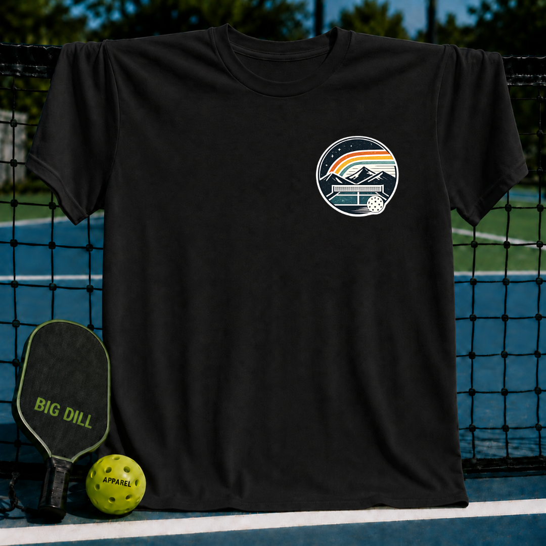 Black unisex t-shirt featuring a circular pickleball crest graphic with mountains, a rainbow, and a court design.