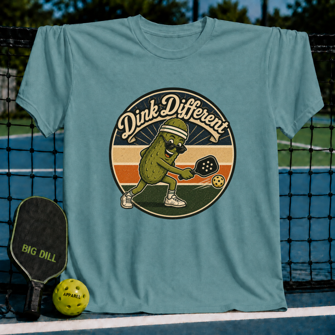 Heather gray unisex t-shirt featuring a retro pickleball graphic of a pickle in a visor and sunglasses mid-swing.