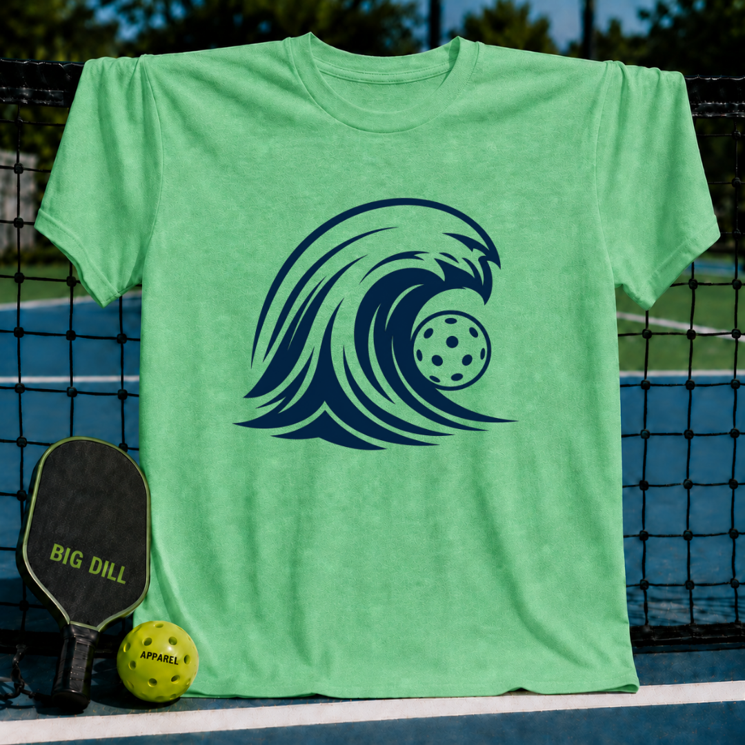 Mint green unisex t-shirt featuring a bold navy blue graphic of a cresting wave with a pickleball in the barrel.