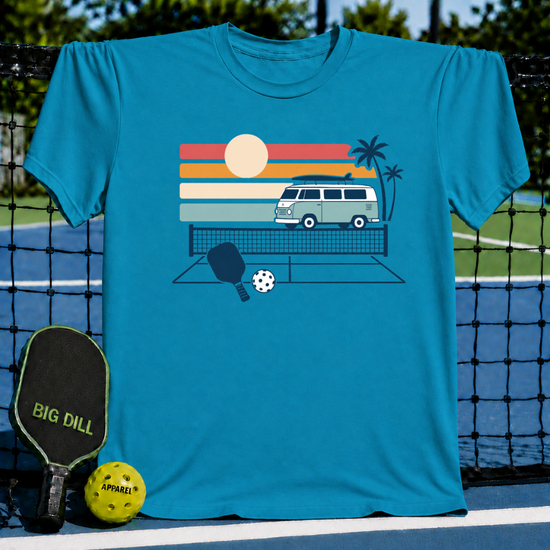 Teal crewneck t-shirt featuring a retro van, palm trees, and pickleball court graphic on a pickleball court background.