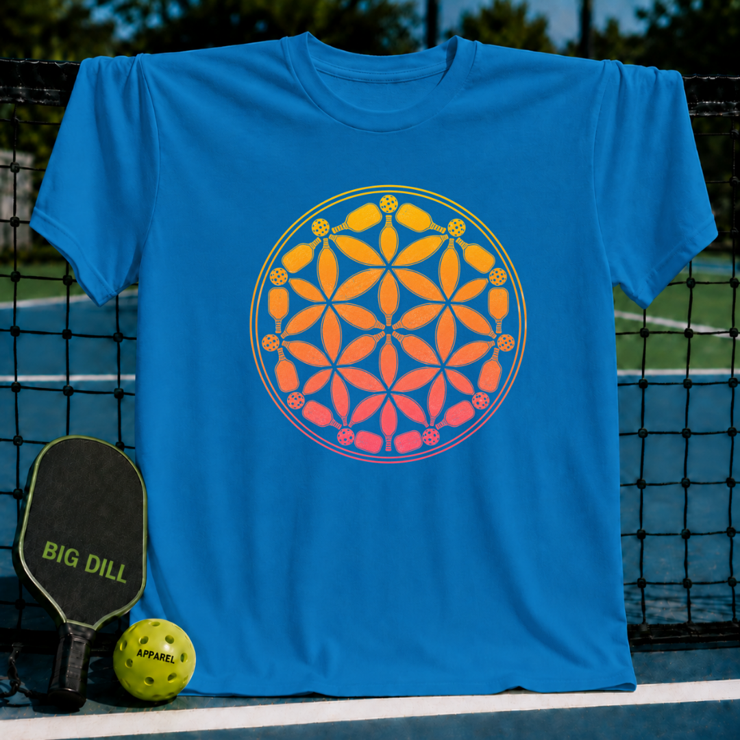 Bright blue t-shirt featuring a yellow-to-pink gradient Flower of Life design made of pickleball paddles and balls.