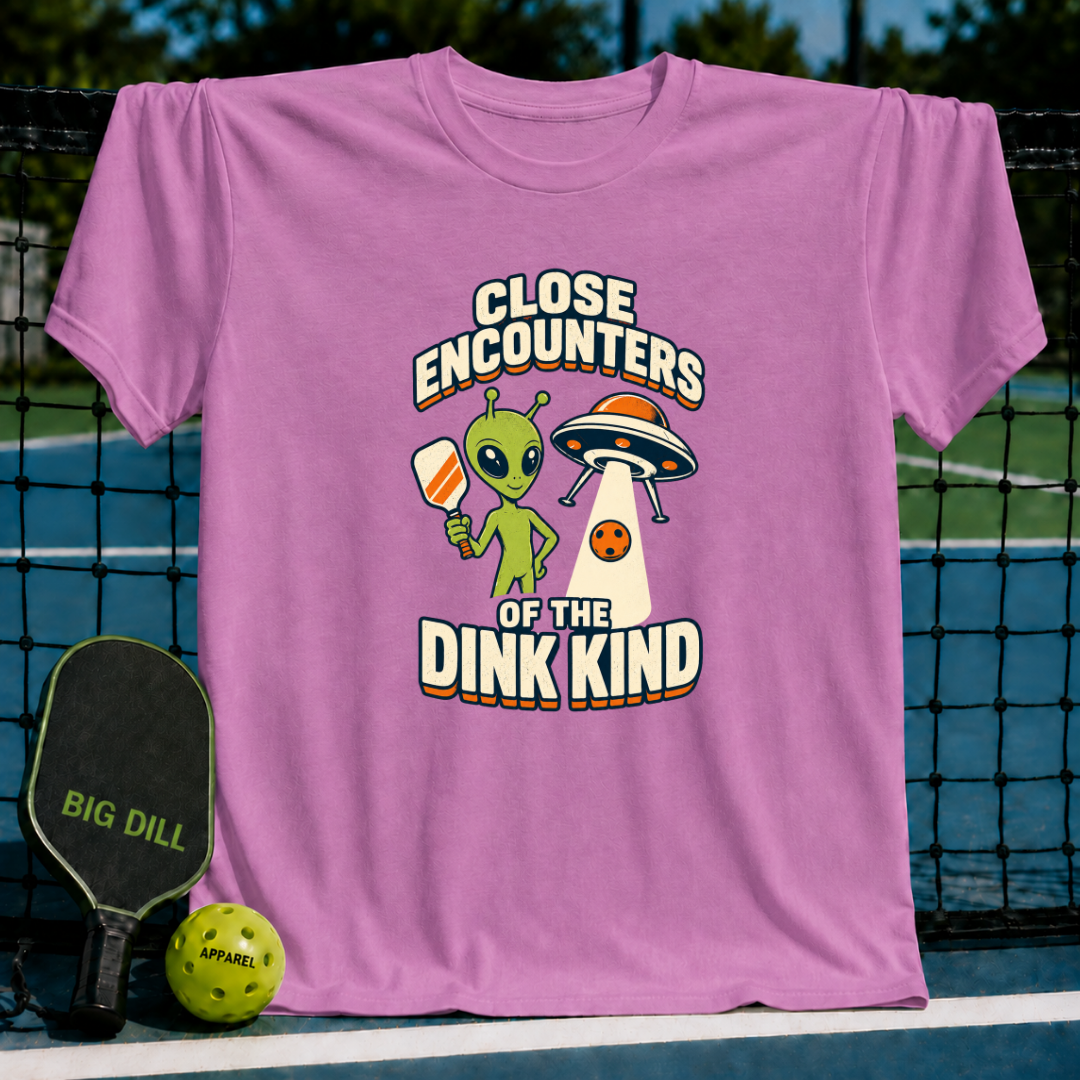 Pink cotton t-shirt featuring a green alien holding a pickleball paddle and a UFO graphic with Close Encounters text.
