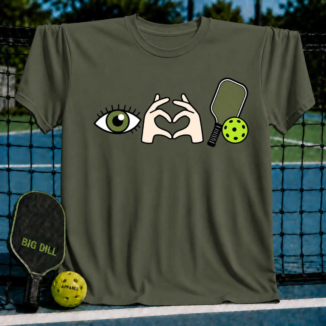 Olive green crewneck t-shirt featuring an eye, heart-shaped hands, and pickleball paddle graphic on a court background.
