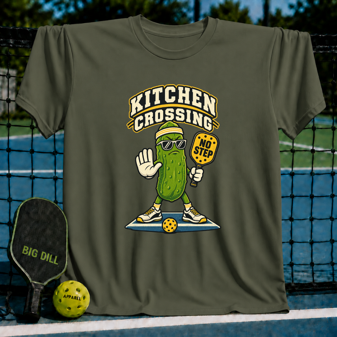 Olive green t-shirt featuring a pickleball-playing pickle character with sunglasses and a No Step paddle graphic.