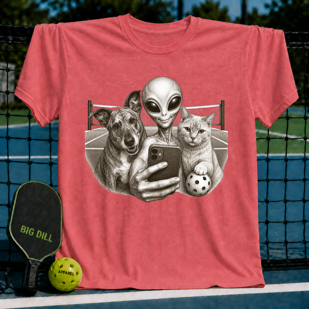 Red unisex t-shirt featuring a vintage-style illustration of an alien, dog, and cat taking a selfie on a pickleball court.