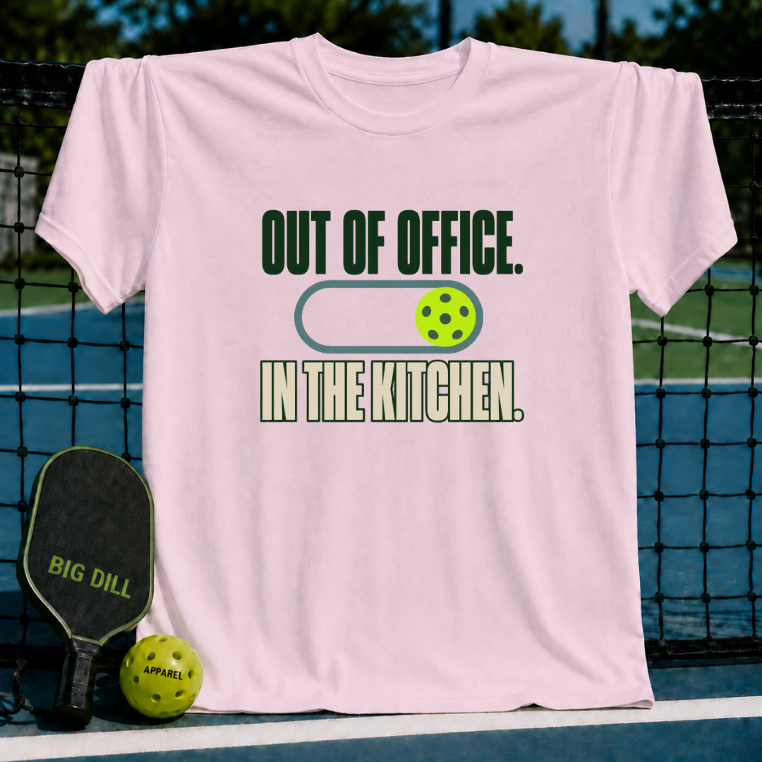 Light pink crewneck t-shirt featuring a pickleball-themed Out of Office In the Kitchen graphic design.