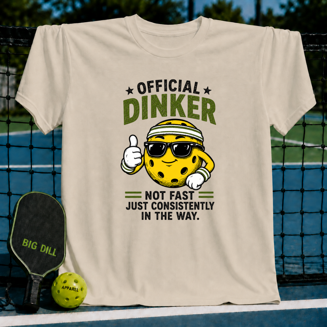 Beige cotton T-shirt featuring a cartoon pickleball character with sunglasses and the text Official Dinker.