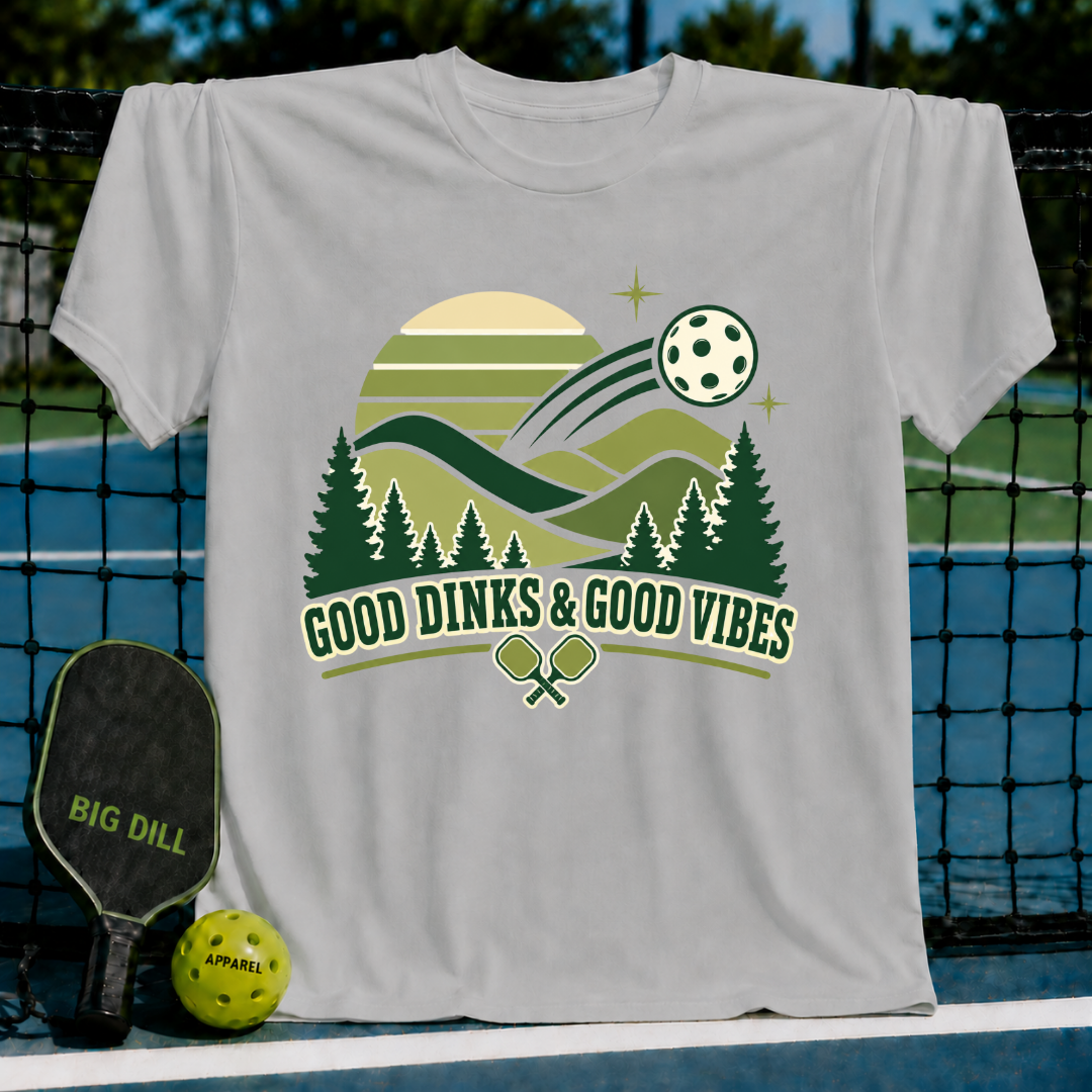 Light gray cotton t-shirt featuring a green pickleball landscape graphic with the text Good Dinks & Good Vibes.