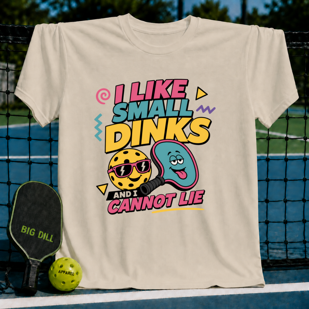 Beige cotton t-shirt featuring a colorful 90s-style pickleball graphic with a smiling ball and paddle design.
