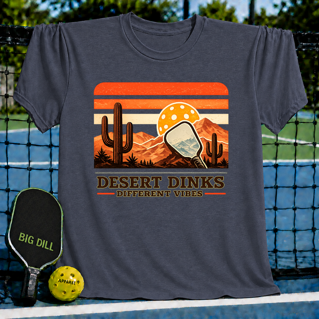 Charcoal grey Desert Dinks t-shirt featuring a retro desert sunset, cactus, and pickleball paddle graphic design.
