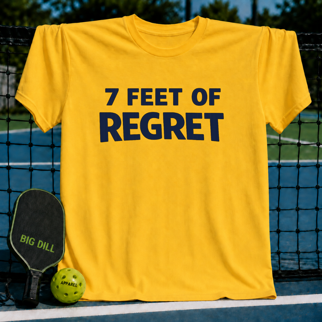 Vivid yellow unisex t-shirt with navy blue 7 FEET OF REGRET text, displayed on a pickleball court with a paddle and ball.