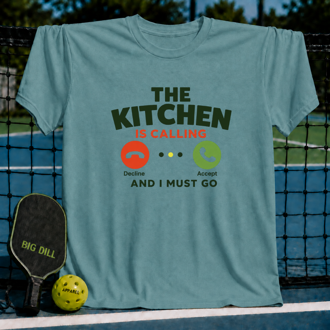 Blue unisex T-shirt featuring a Kitchen Is Calling phone UI graphic with decline and accept buttons on a pickleball court.