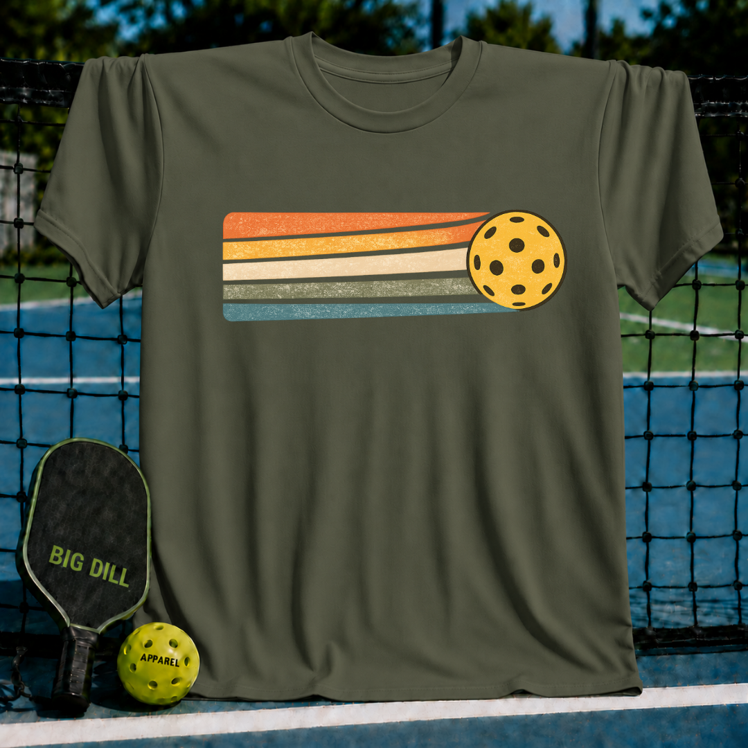 Olive green unisex t-shirt featuring a yellow pickleball with retro orange, cream, and teal motion stripes.