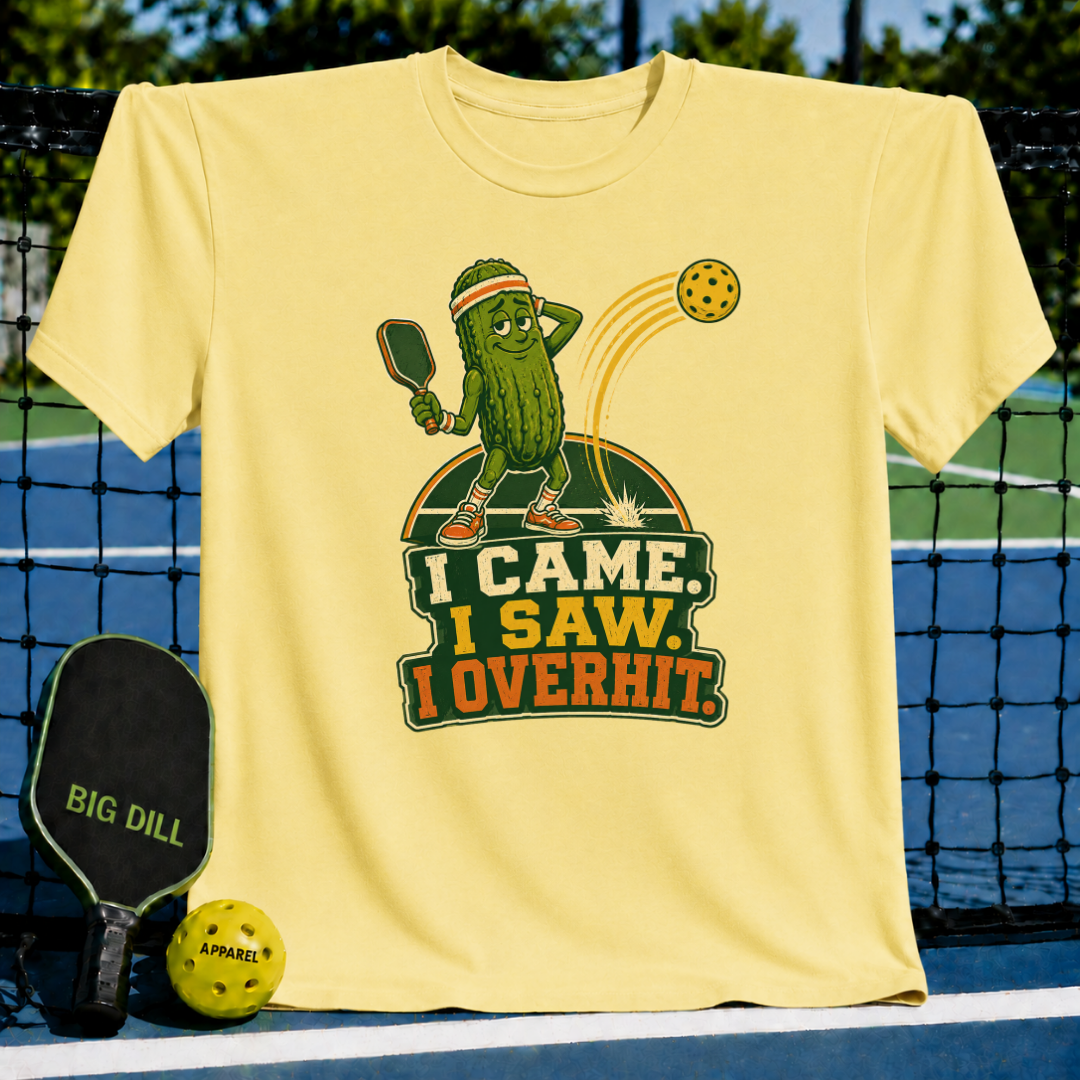 Light yellow Overhitter pickleball t-shirt featuring a cartoon pickle player graphic and the text I Came, I Saw, I Overhit.
