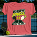 Coral pink crewneck t-shirt featuring a Down the Middle pickleball graphic with paddles, a split ball, and court background.