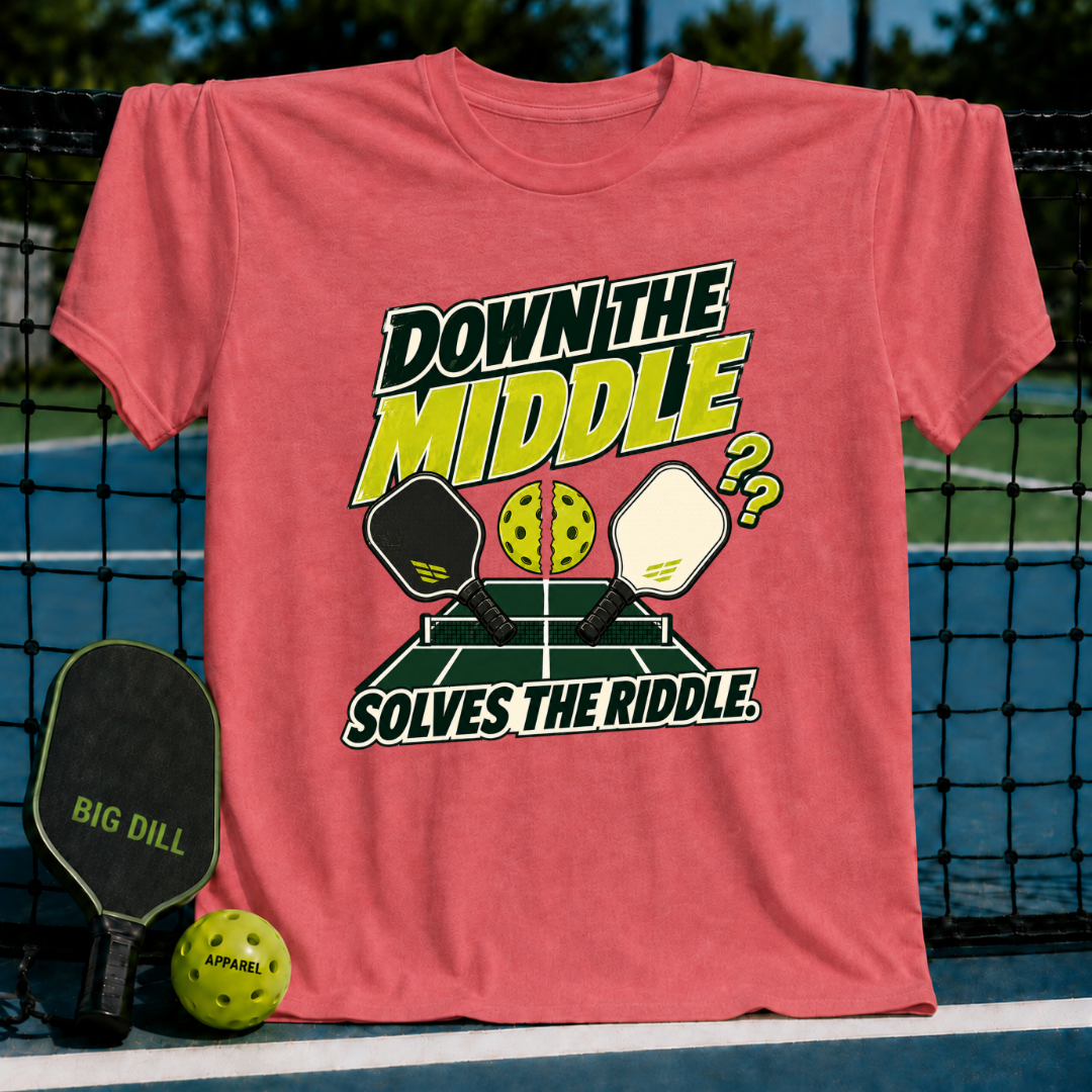 Coral pink crewneck t-shirt featuring a Down the Middle pickleball graphic with paddles, a split ball, and court background.