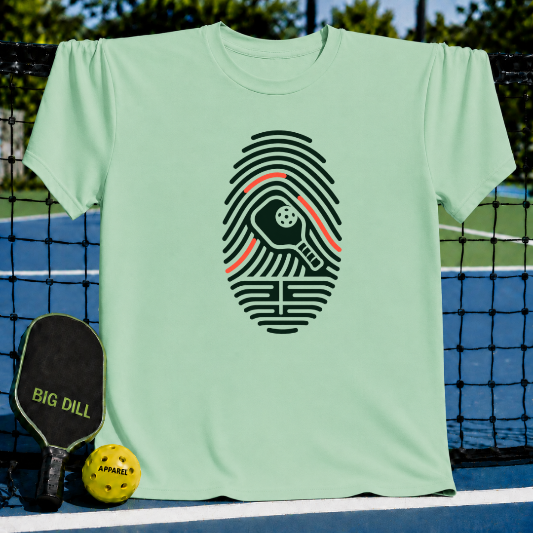 Light green crew neck t-shirt featuring a dark green fingerprint graphic with a pickleball paddle and ball design.