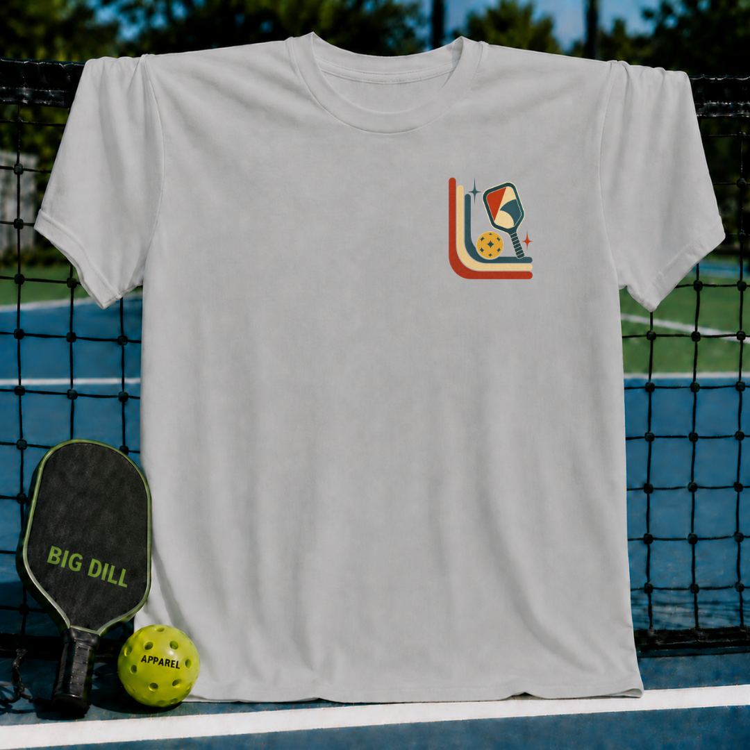 Light gray unisex t-shirt featuring a mid-century retro pickleball graphic on a pickleball court background.