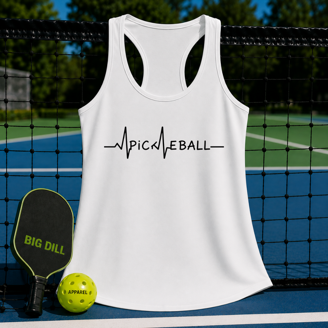 White racerback tank top with black Pickleball EKG heartbeat graphic, displayed on a pickleball court with paddle and ball.