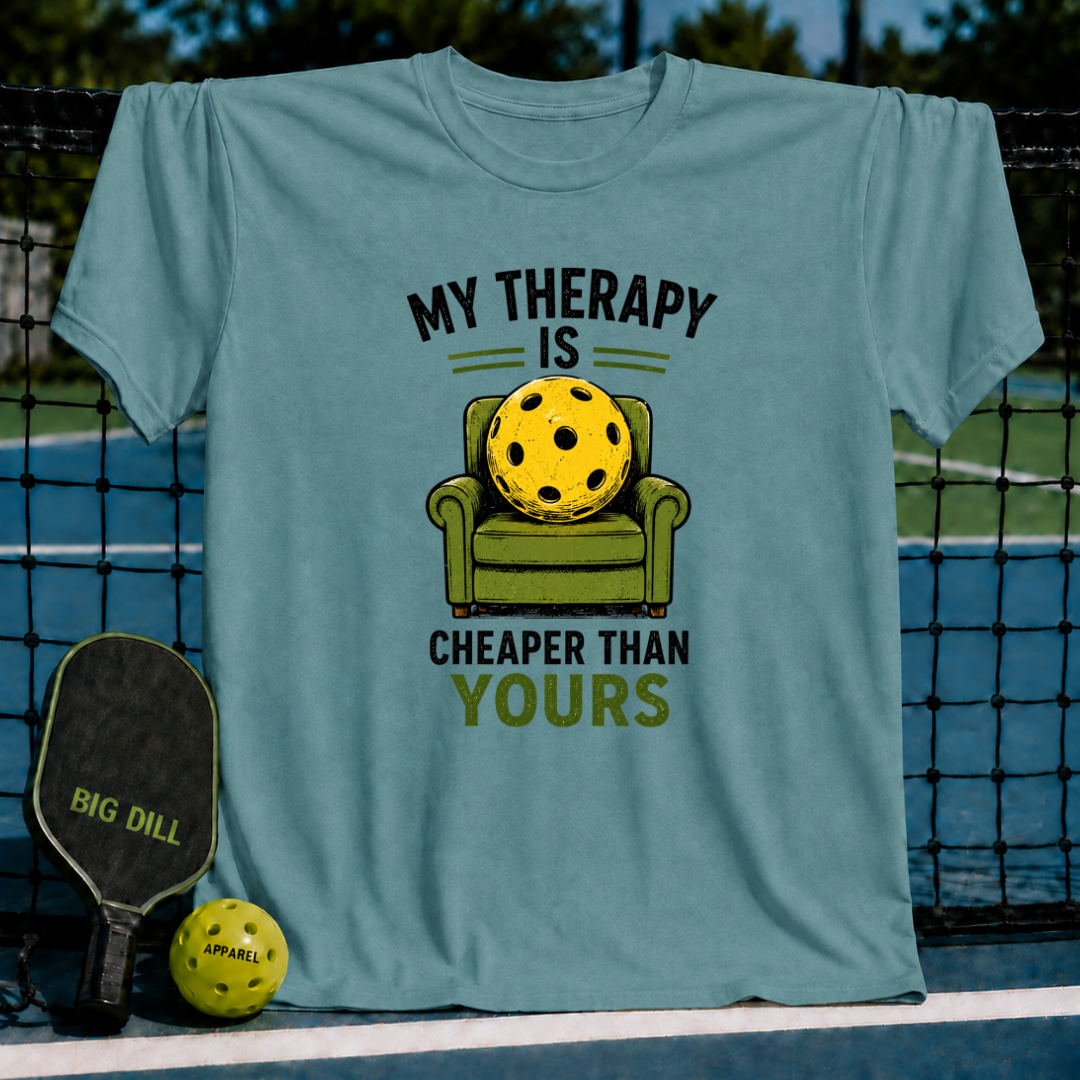 Blue-grey unisex t-shirt featuring a yellow pickleball sitting in a green armchair with the text My Therapy Is Cheaper Than Yours.