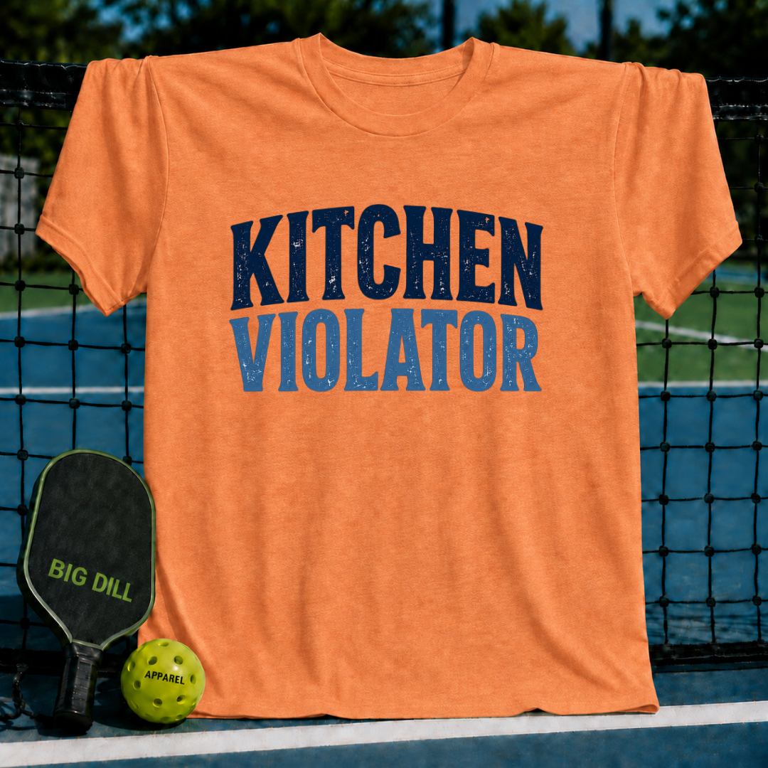 Orange unisex t-shirt featuring distressed Kitchen Violator varsity lettering, displayed on a pickleball court net.