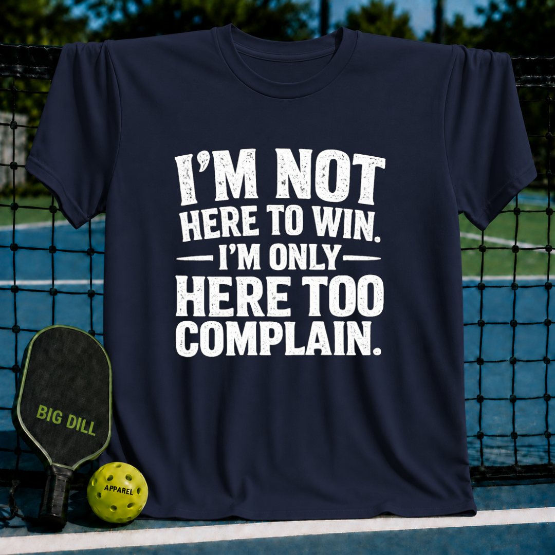 Navy blue unisex t-shirt with distressed white text reading I'm Not Here to Win, I'm Only Here Too Complain on a pickleball court.