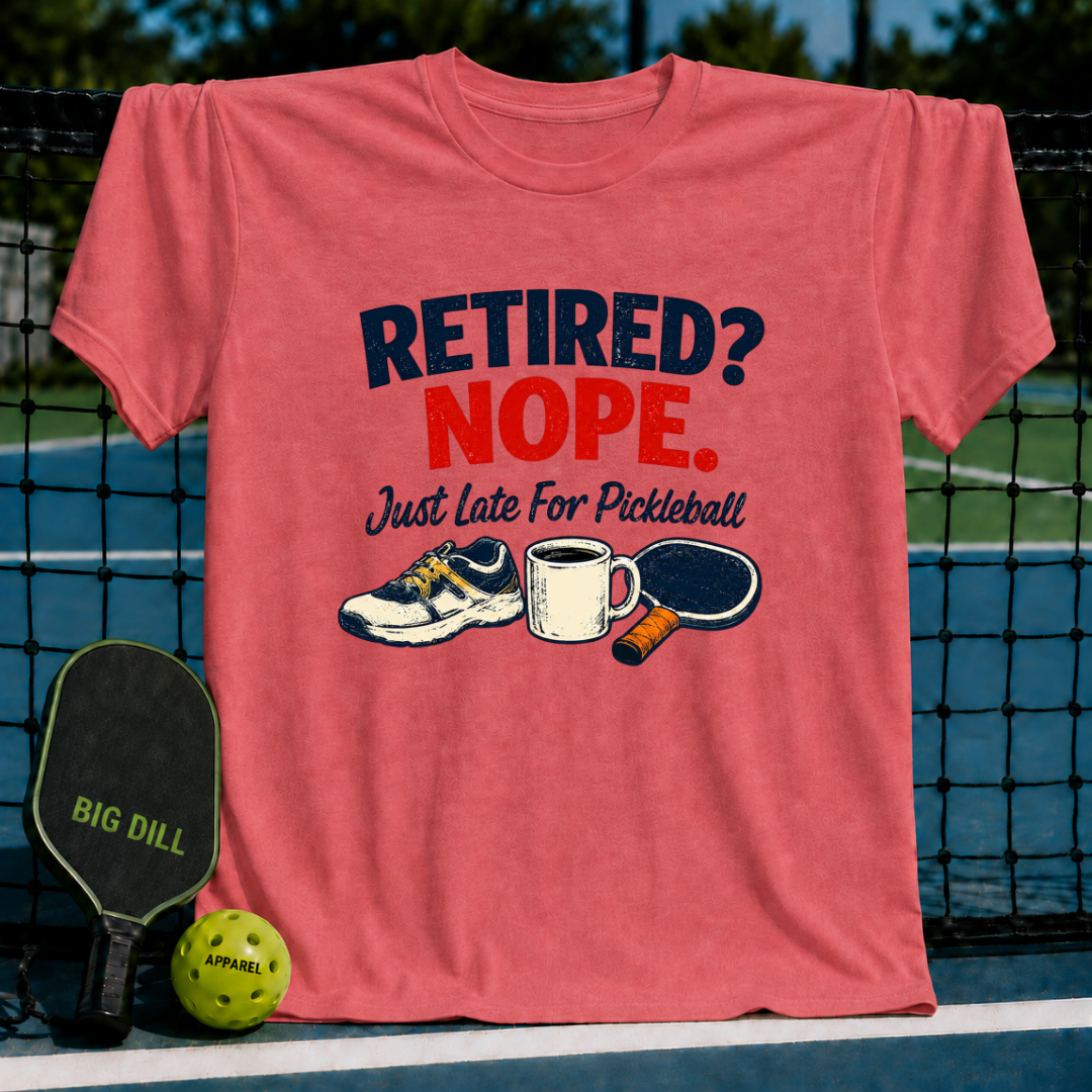 Coral red cotton t-shirt featuring a Retired? Nope. Just Late For Pickleball graphic with a sneaker, coffee mug, and paddle.