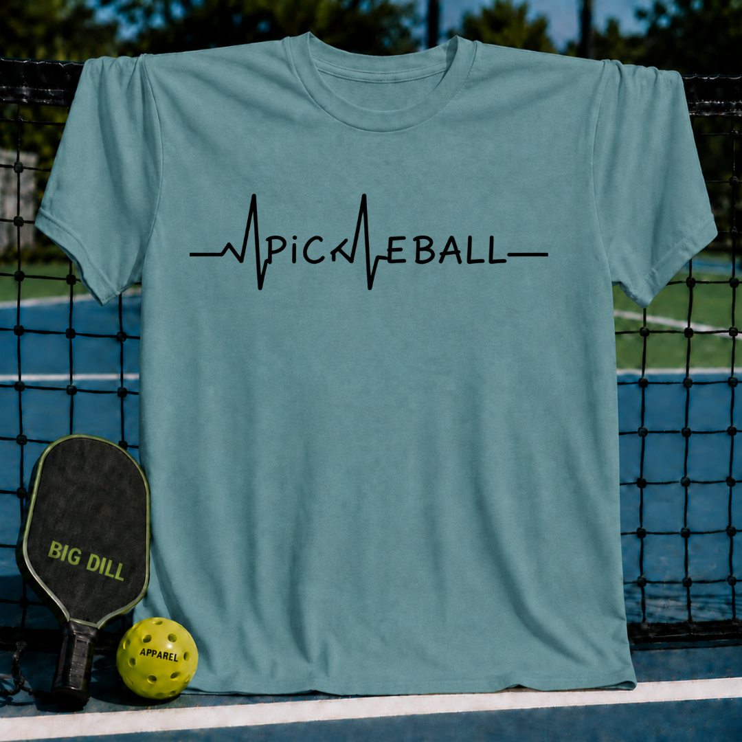Blue-grey unisex t-shirt featuring a black EKG heartbeat graphic that spells out Pickleball, displayed on a court net.
