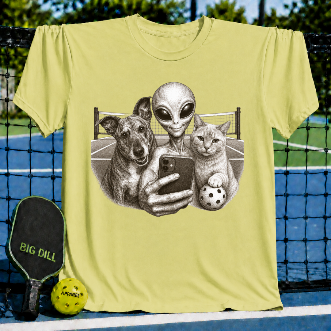 Heather green unisex t-shirt featuring a vintage illustration of an alien, dog, and cat taking a selfie on a pickleball court.