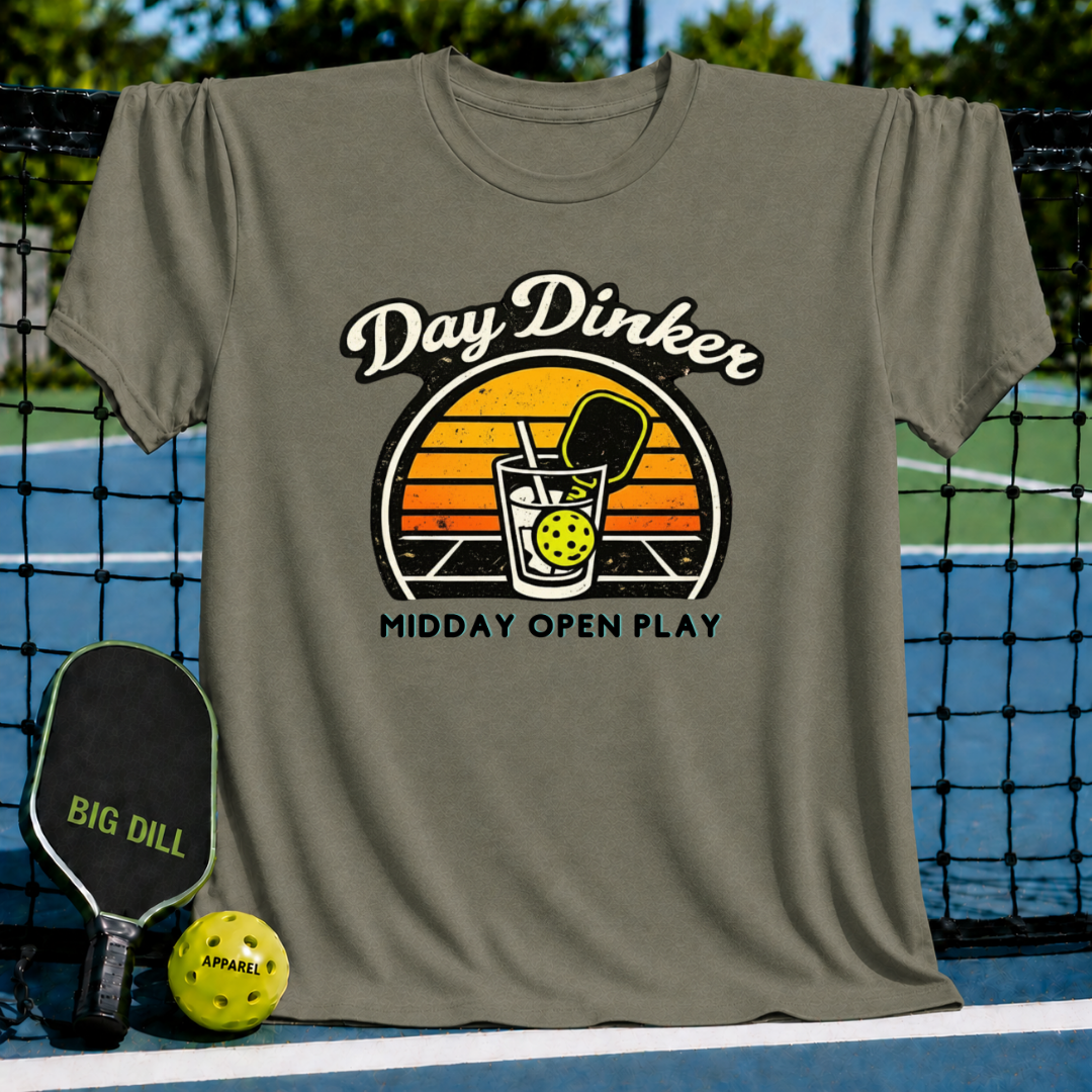 Olive green unisex T-shirt featuring a retro sunset graphic of a pickleball paddle and ball in a glass.