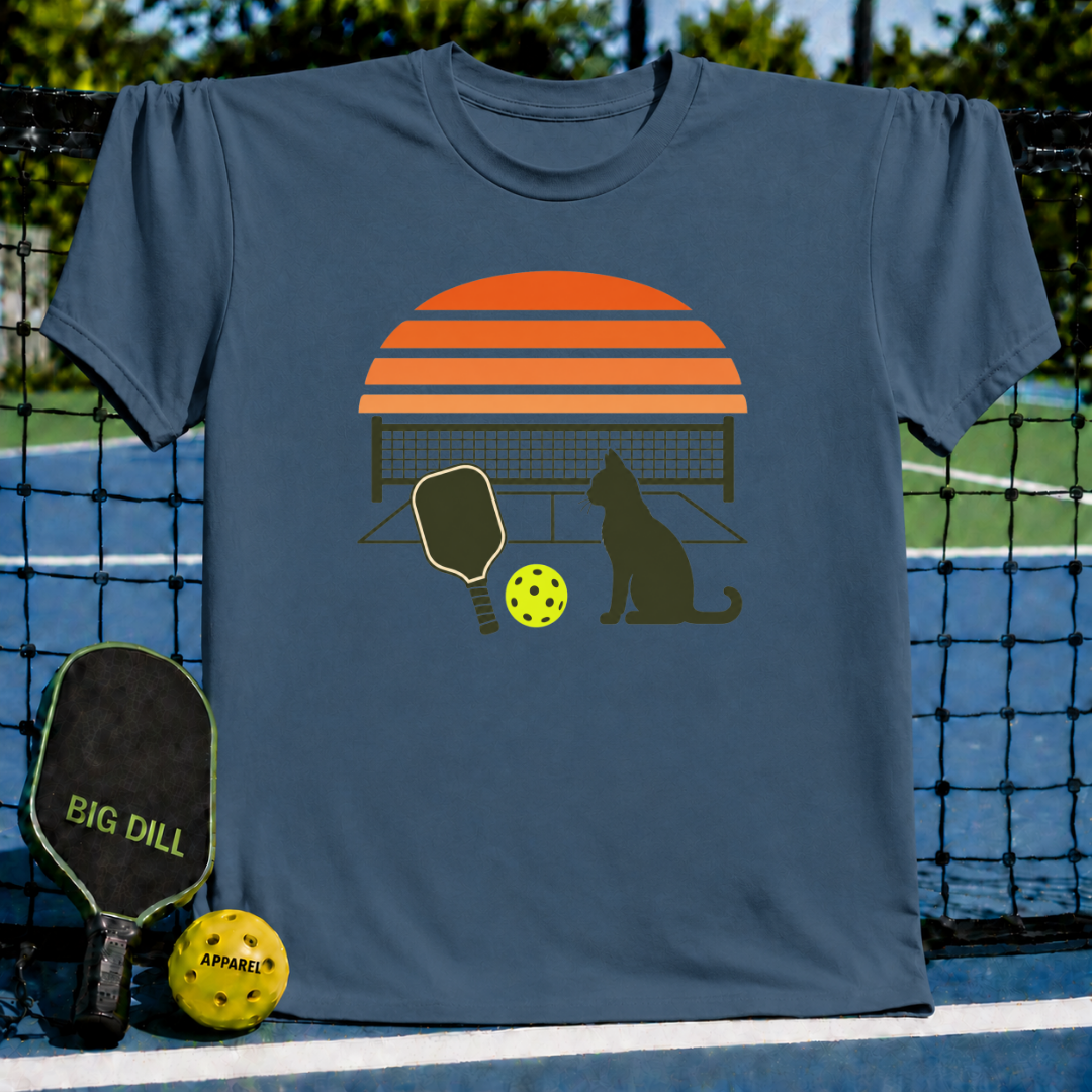 Blue unisex t-shirt featuring a retro sunset, pickleball paddle, ball, and cat silhouette graphic.