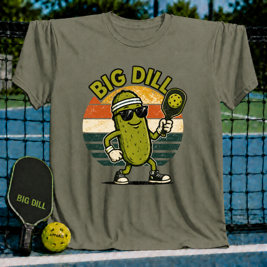 Olive green unisex t-shirt featuring a retro pickleball-playing pickle graphic with sunglasses inside a sunset circle.