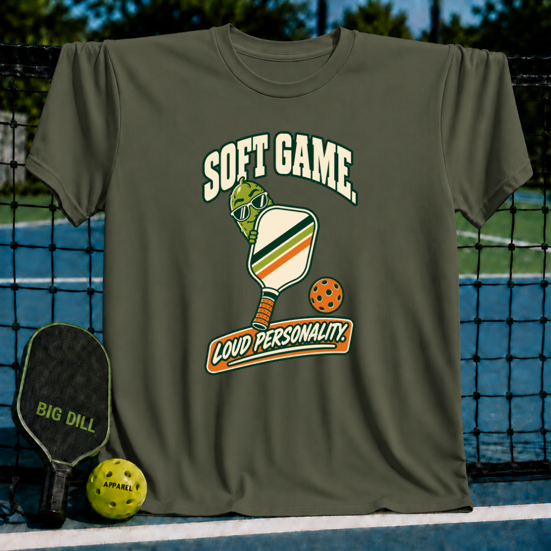 Olive green crewneck t-shirt featuring a pickleball graphic with sunglasses and the text Soft Game, Loud Personality.