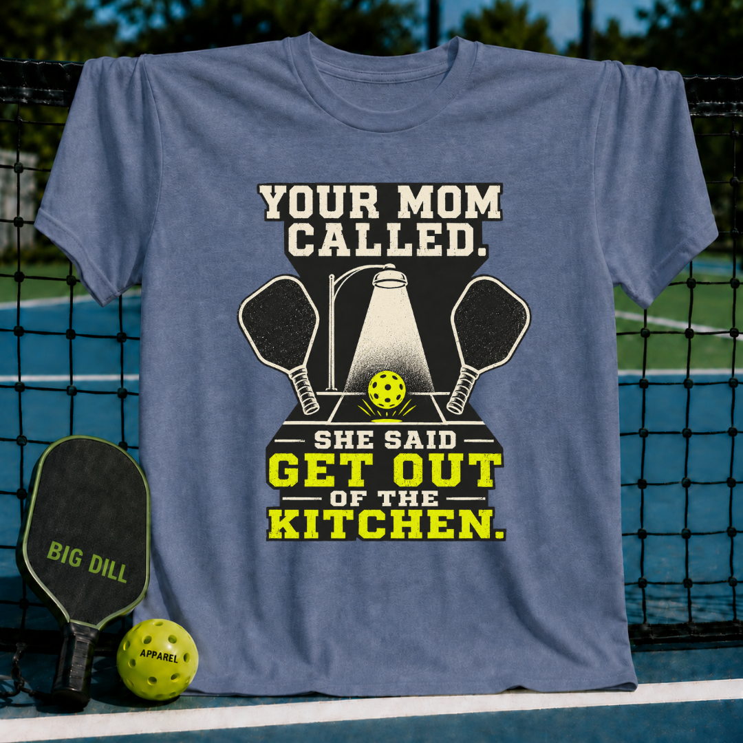 Blue unisex pickleball t-shirt featuring a spotlight graphic, crossed paddles, and the text Your Mom Called Get Out Of The Kitchen.