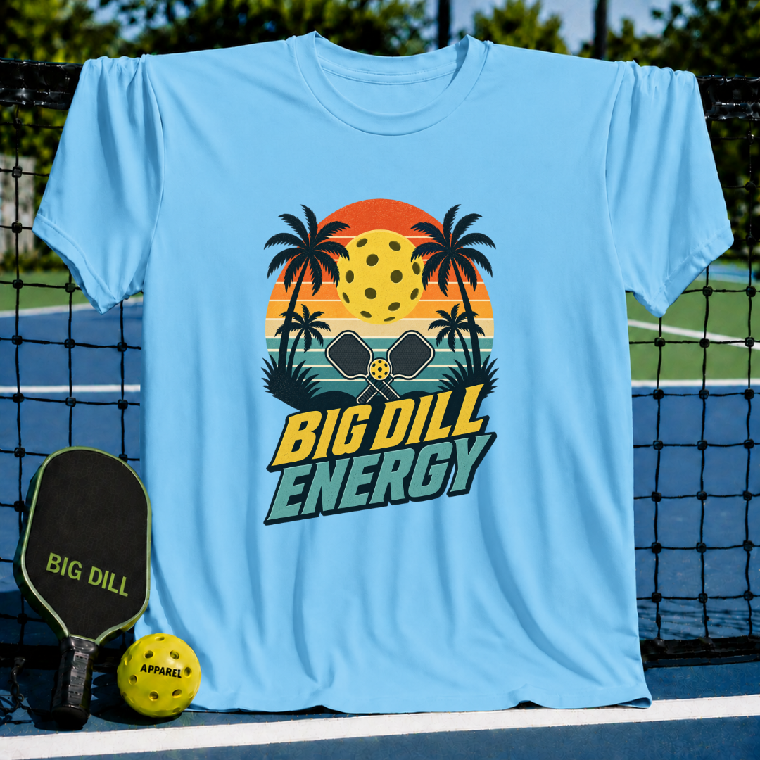 Light blue T-shirt featuring a retro sunset, palm trees, and pickleball graphic with Big Dill Energy text.