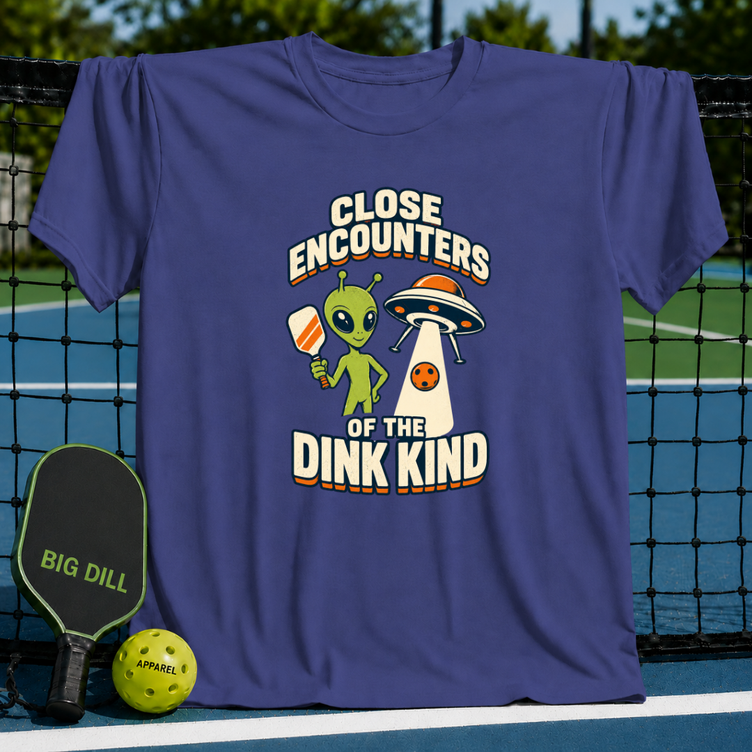 Purple cotton t-shirt featuring an alien holding a pickleball paddle and a UFO graphic with Close Encounters of the Dink Kind text.