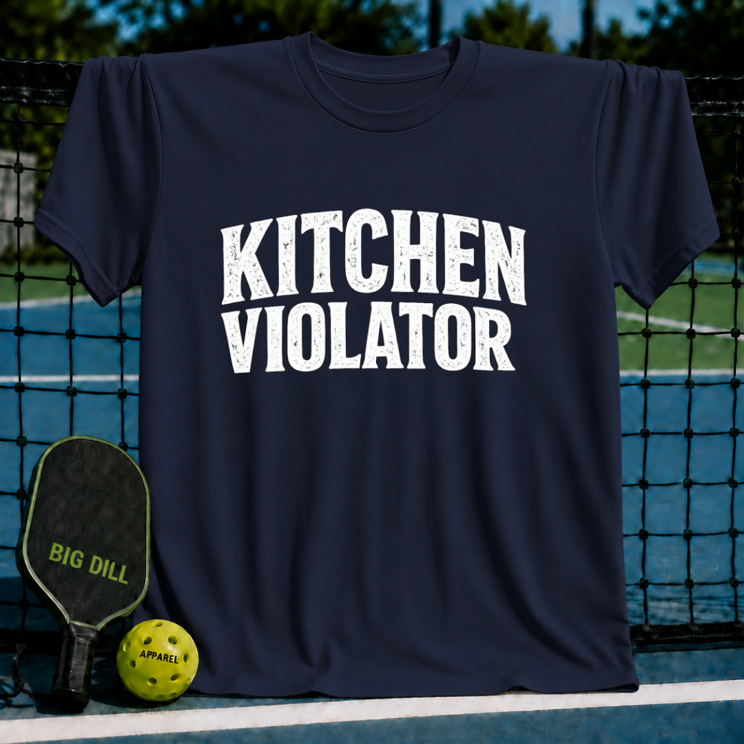 Navy blue unisex t-shirt featuring distressed white varsity lettering that reads Kitchen Violator, displayed on a pickleball court.