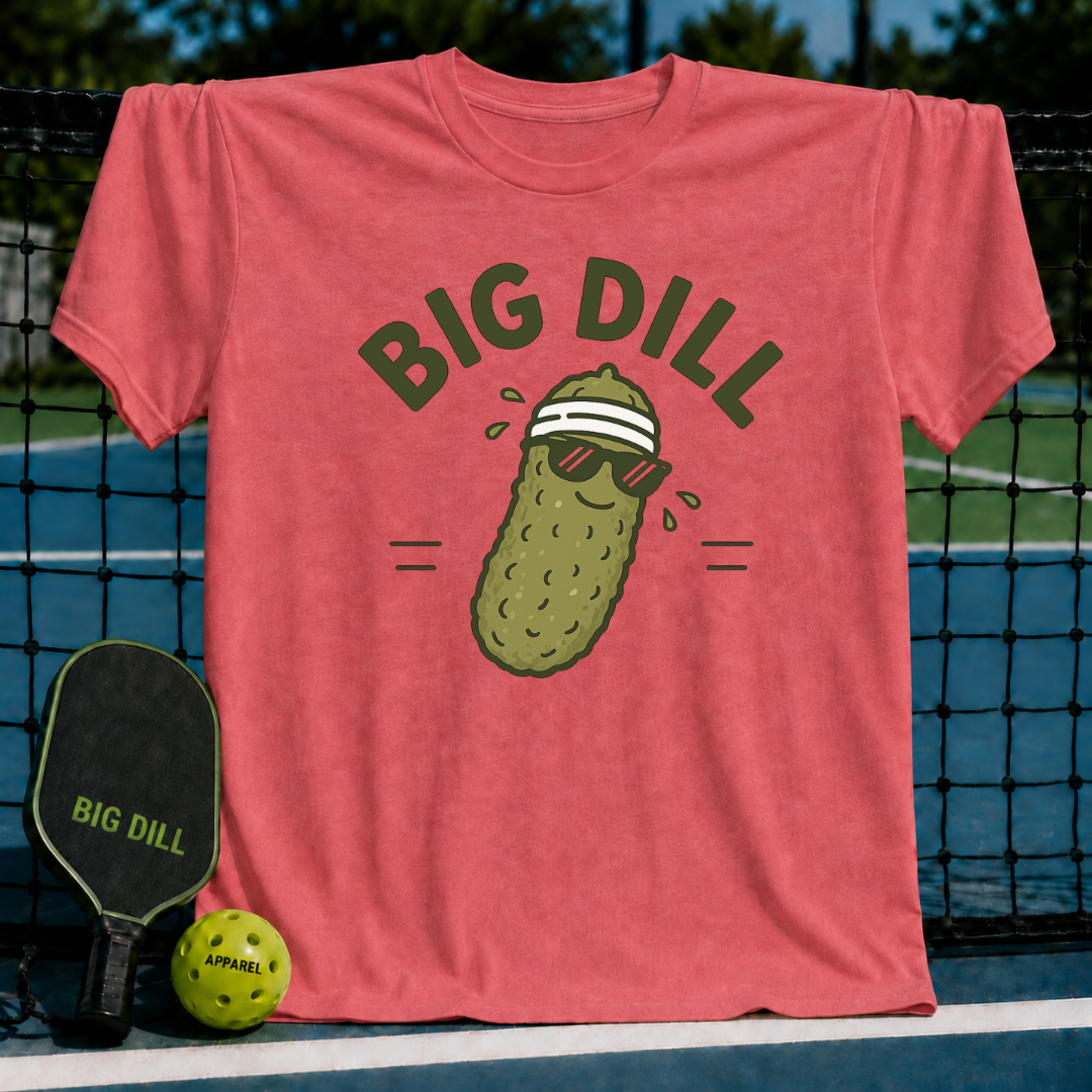 Soft coral unisex t-shirt featuring a graphic of a pickle wearing sunglasses and a sweatband with Big Dill text.