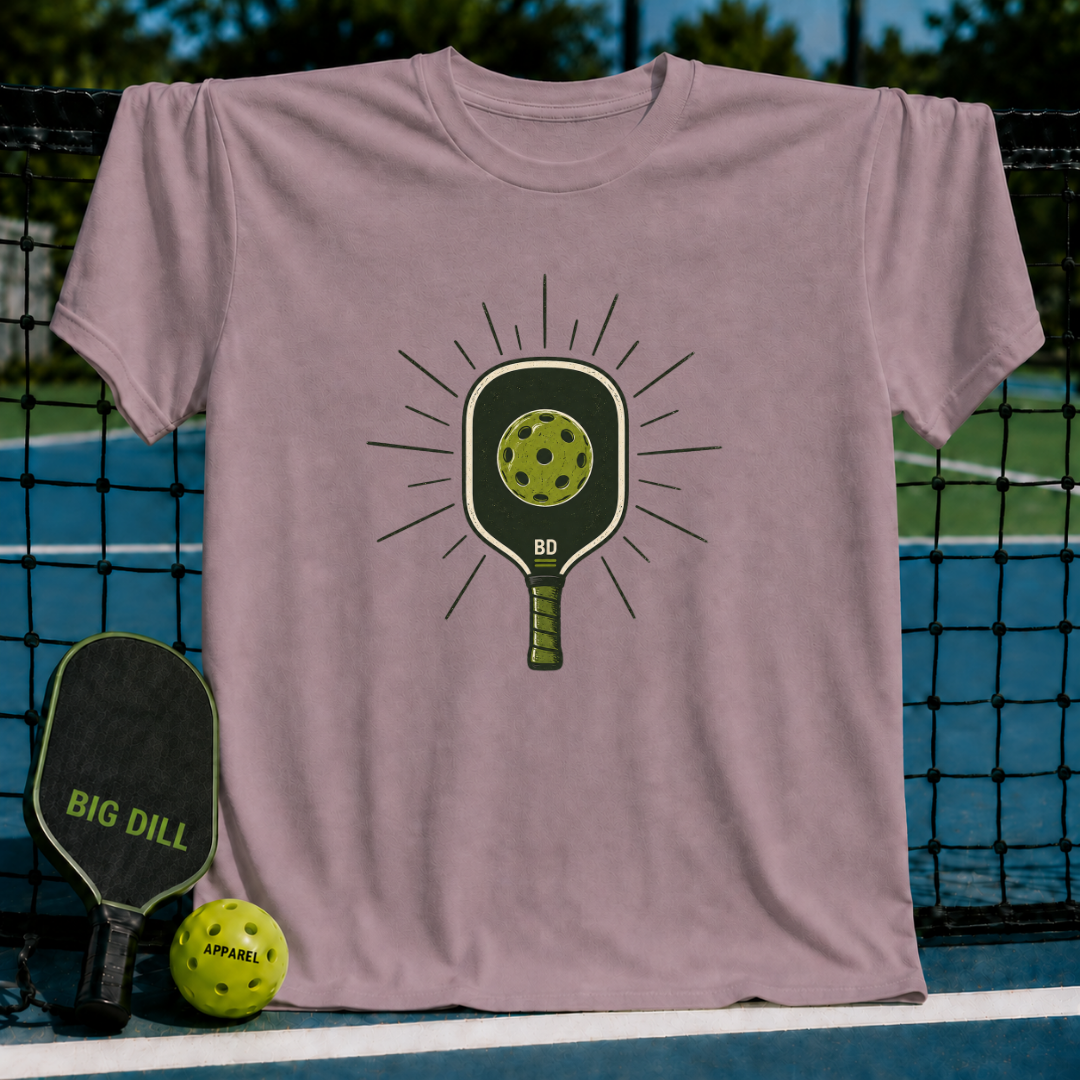 Mauve crewneck t-shirt featuring a vintage-style pickleball paddle and ball graphic on a pickleball court background.