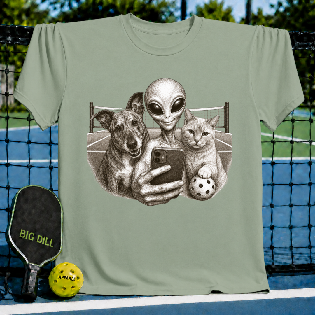 Heather green unisex t-shirt featuring a vintage illustration of an alien, dog, and cat taking a pickleball court selfie.