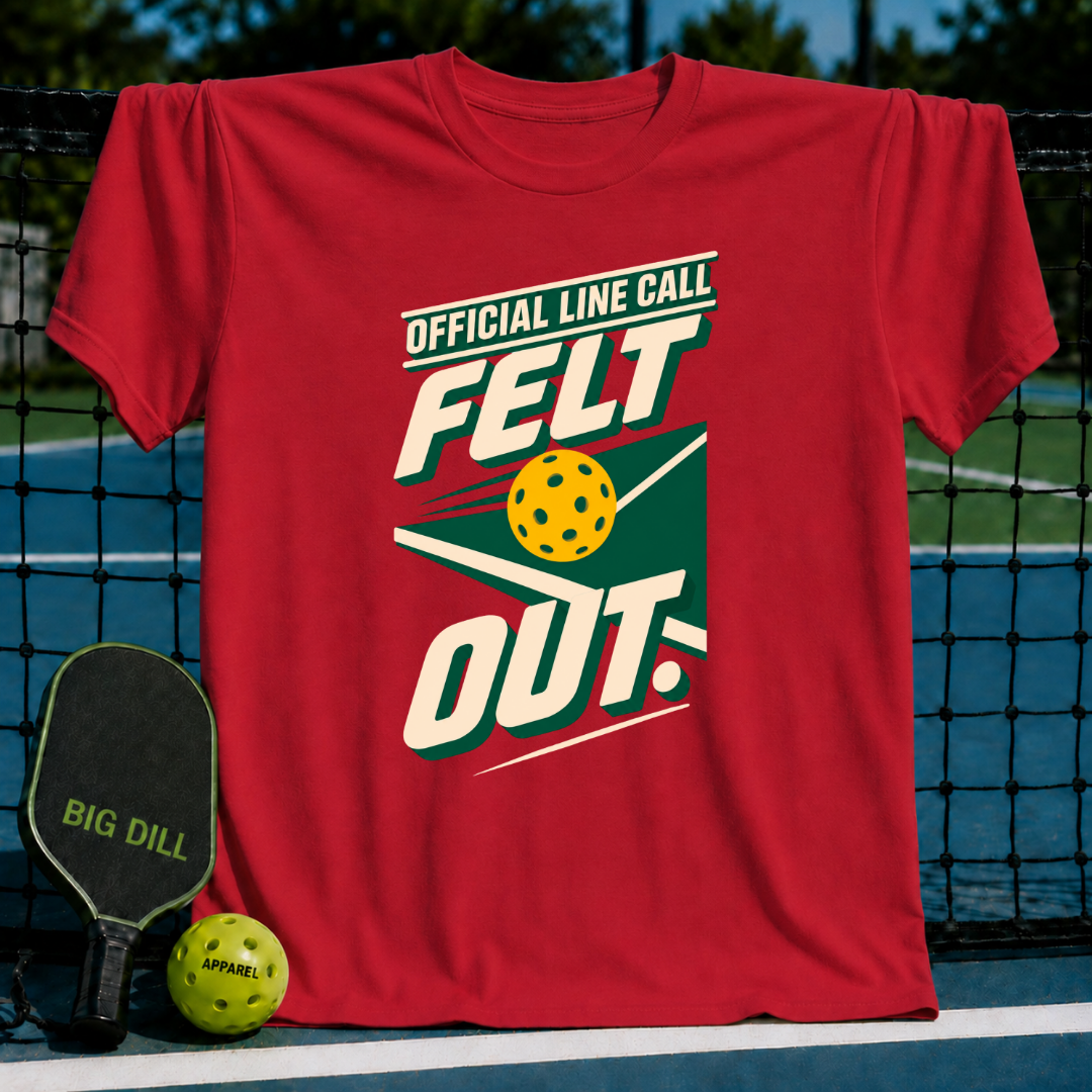 Red crew neck t-shirt featuring Official Line Call Felt Out pickleball graphic, displayed on a court with a paddle and ball.