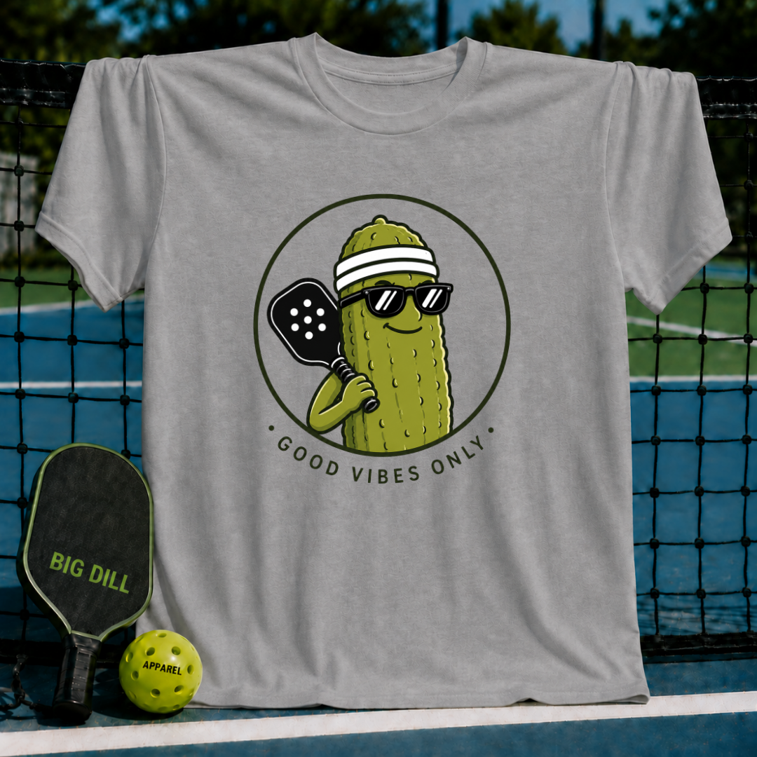 Grey unisex t-shirt featuring a circular graphic of a smiling pickle wearing sunglasses and a visor holding a pickleball paddle.